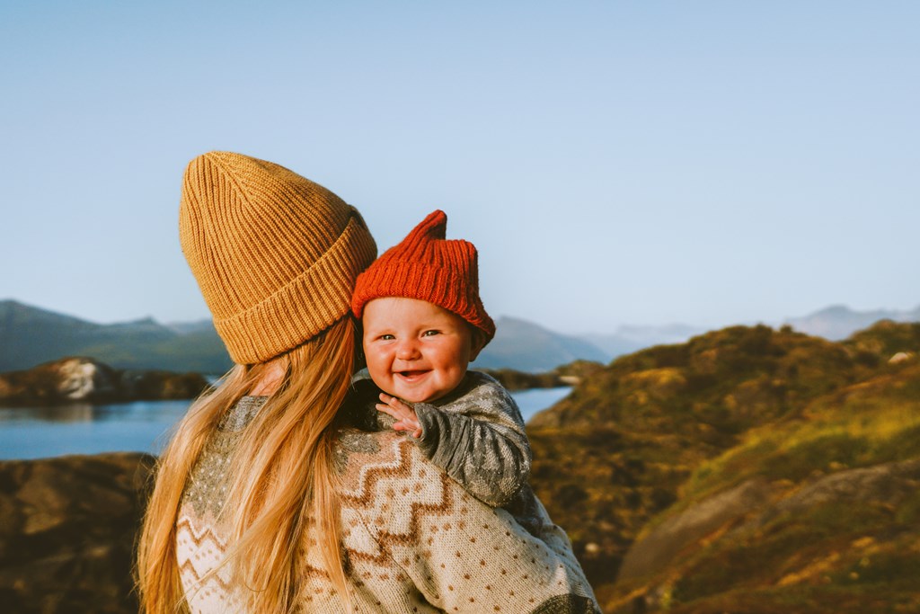 Cute baby and mother walking outdoors. 