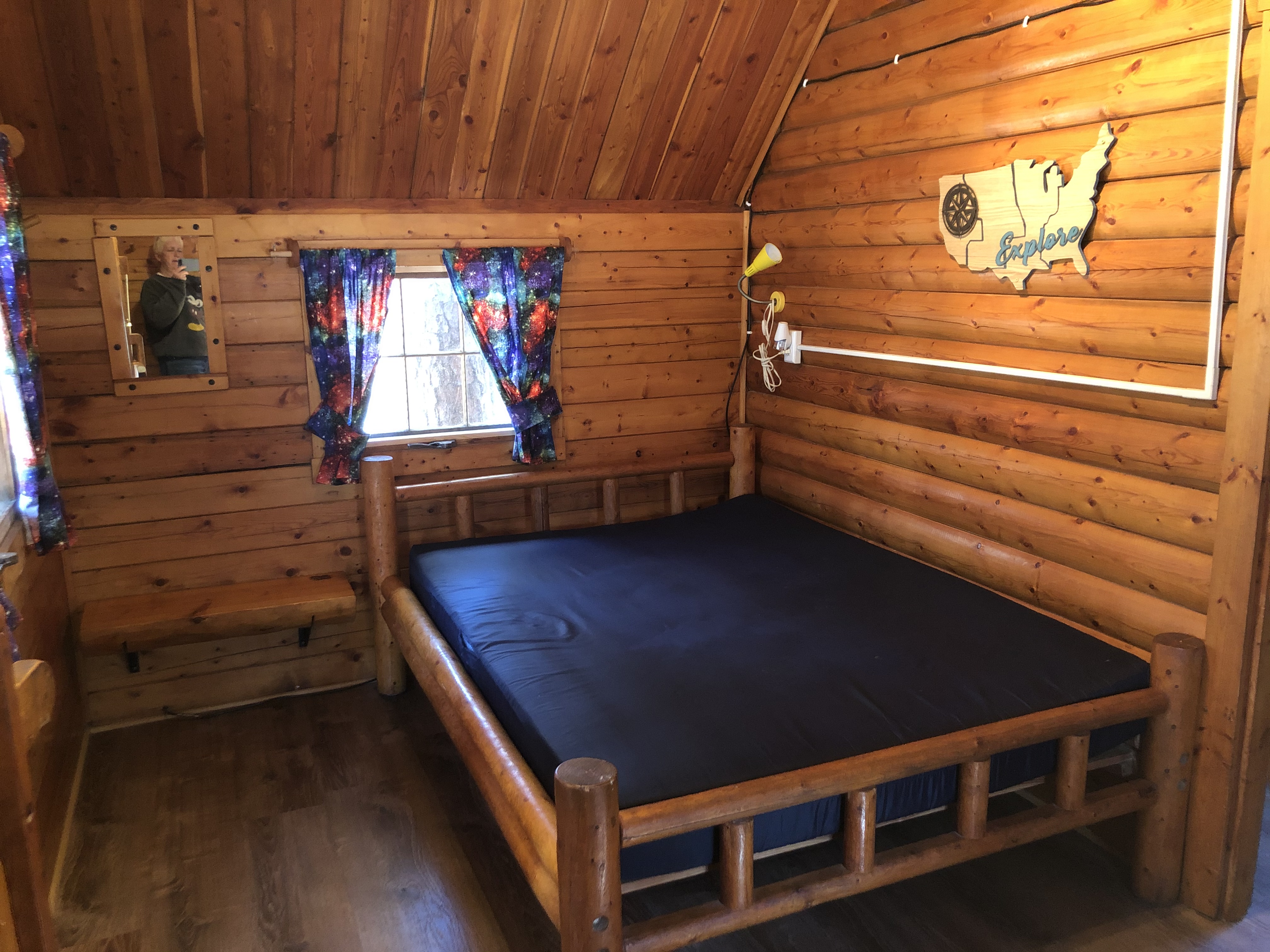 Front room of two room cabin with full size bed.
