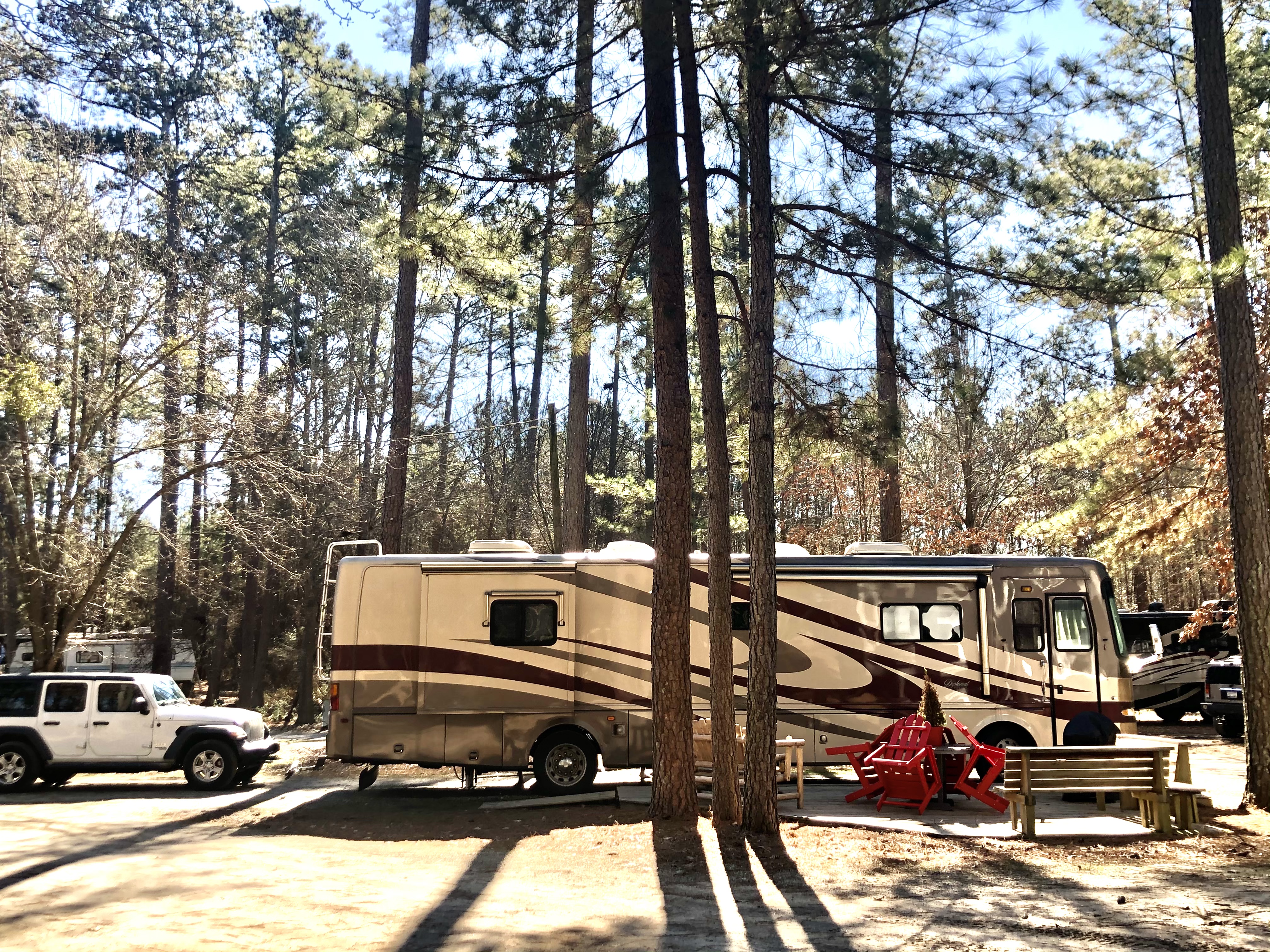 Site 28 with a raised wood deck, picnic table (with umbrella in warmer months), gas grill and glider. Our patio sites are longer and wider.