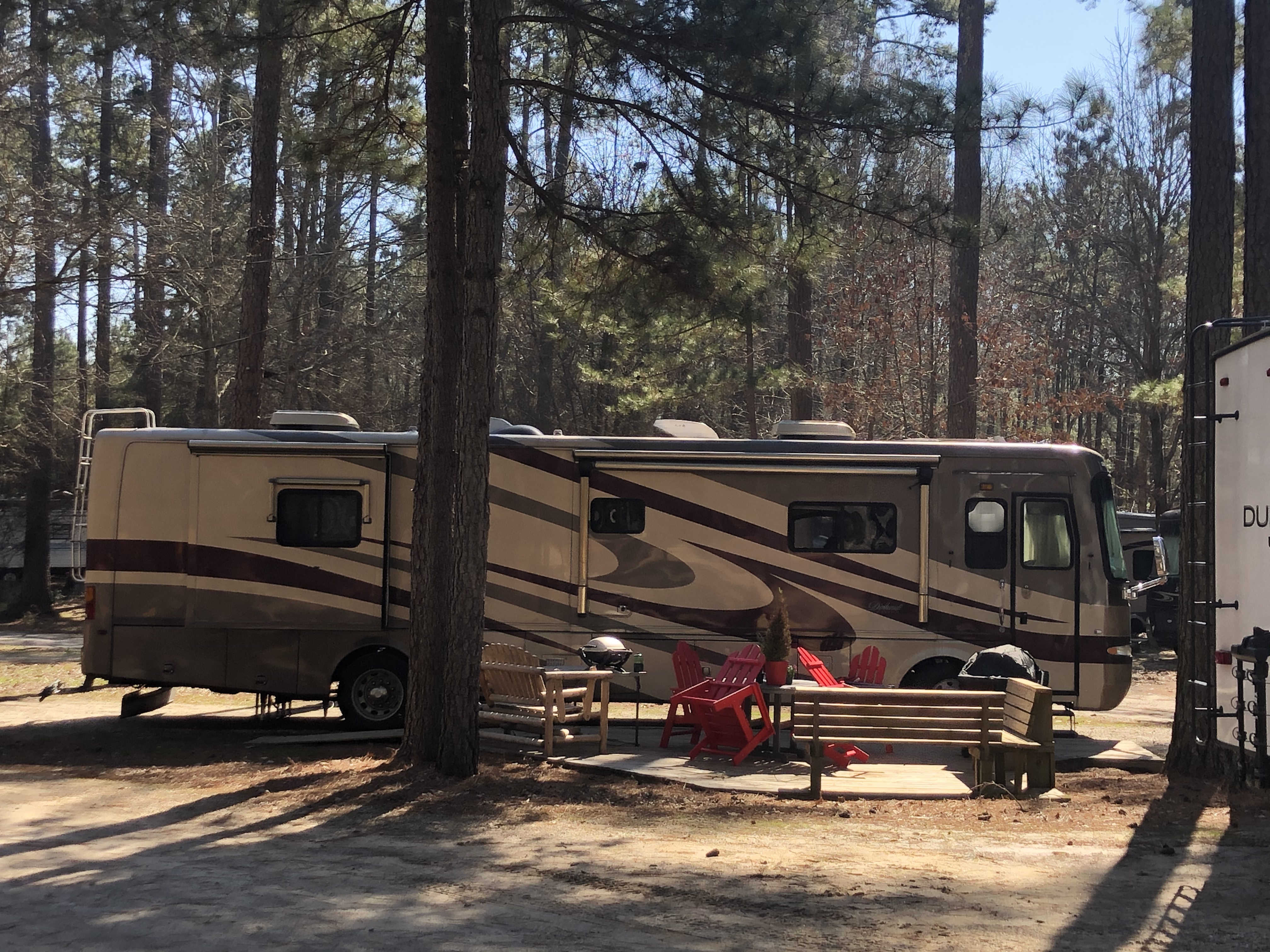 Deluxe patio sites are longer and wider. This one has red paver blocks for its patio and also has a swing, fire pit and gas grill. The picnic table has an umbrella during the warmer months.