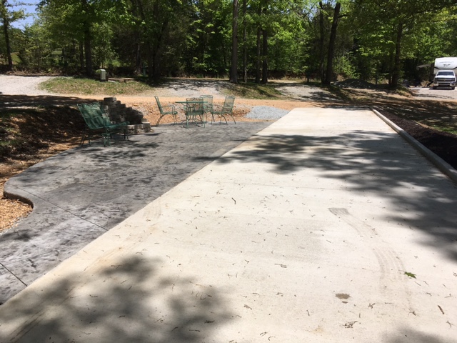 Patio Site with  concrete RV pad, concrete patio with stone fire pit, glider, table and 4 chairs and a Blackstone griddle.