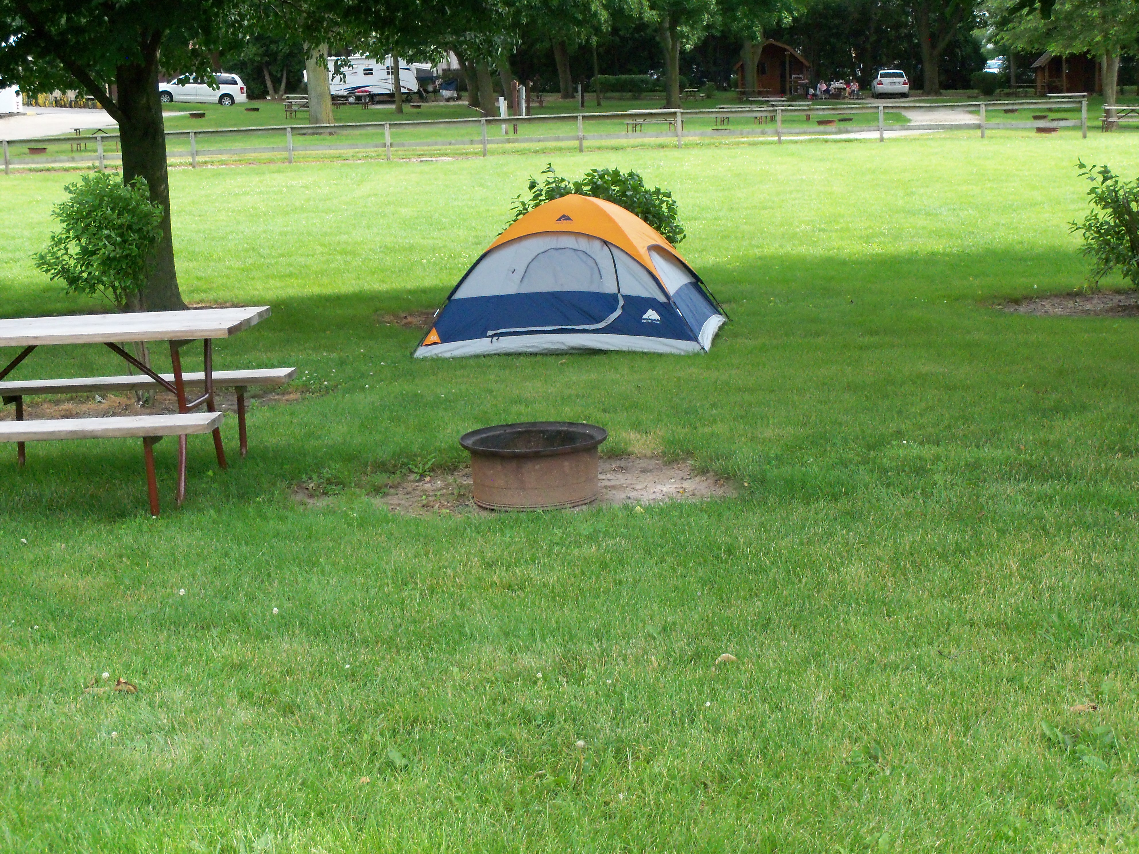 Shaded tent site near playground.