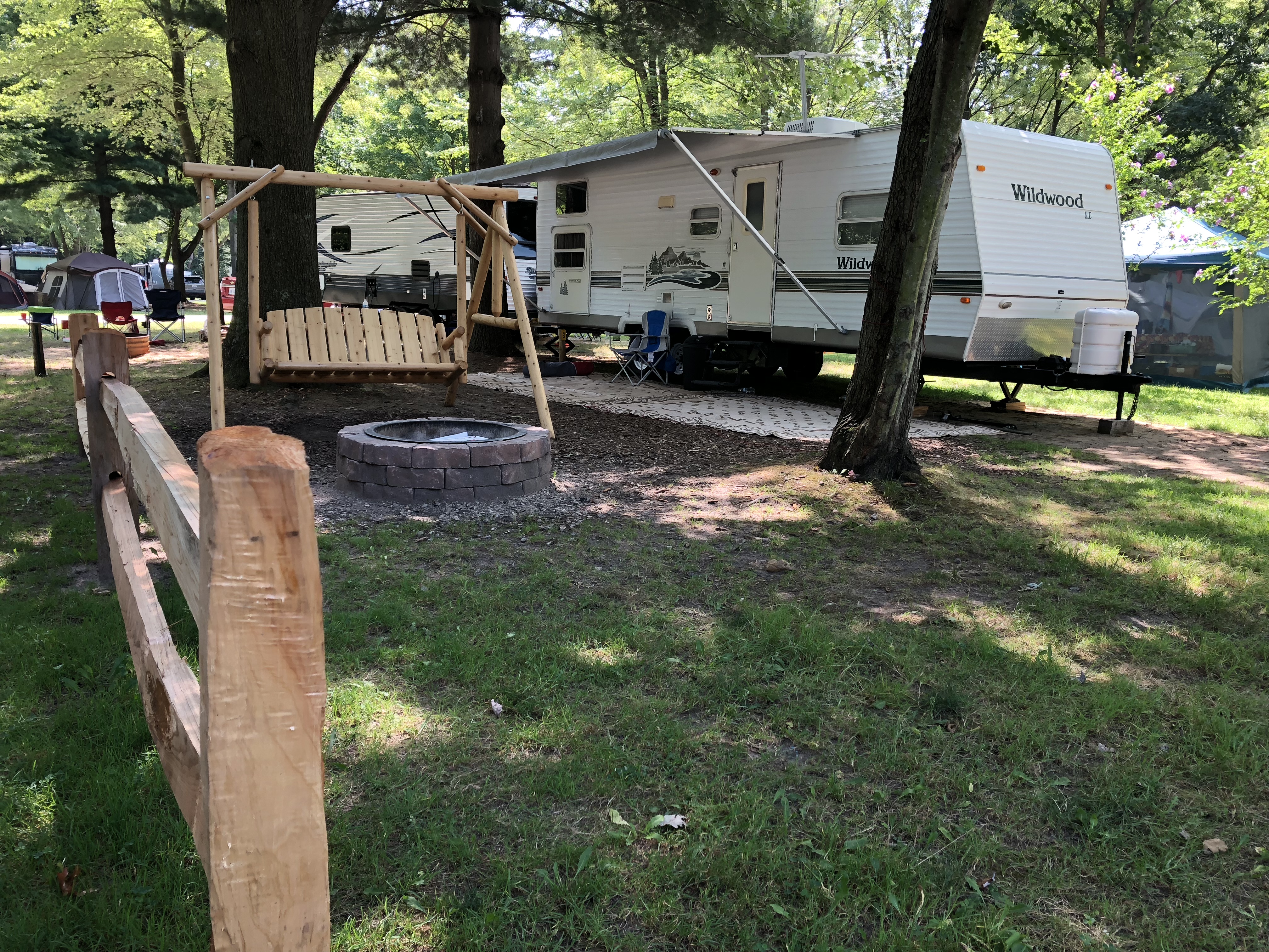 Premium Water & Electric RV site with rustic swing and enhanced fire ring.