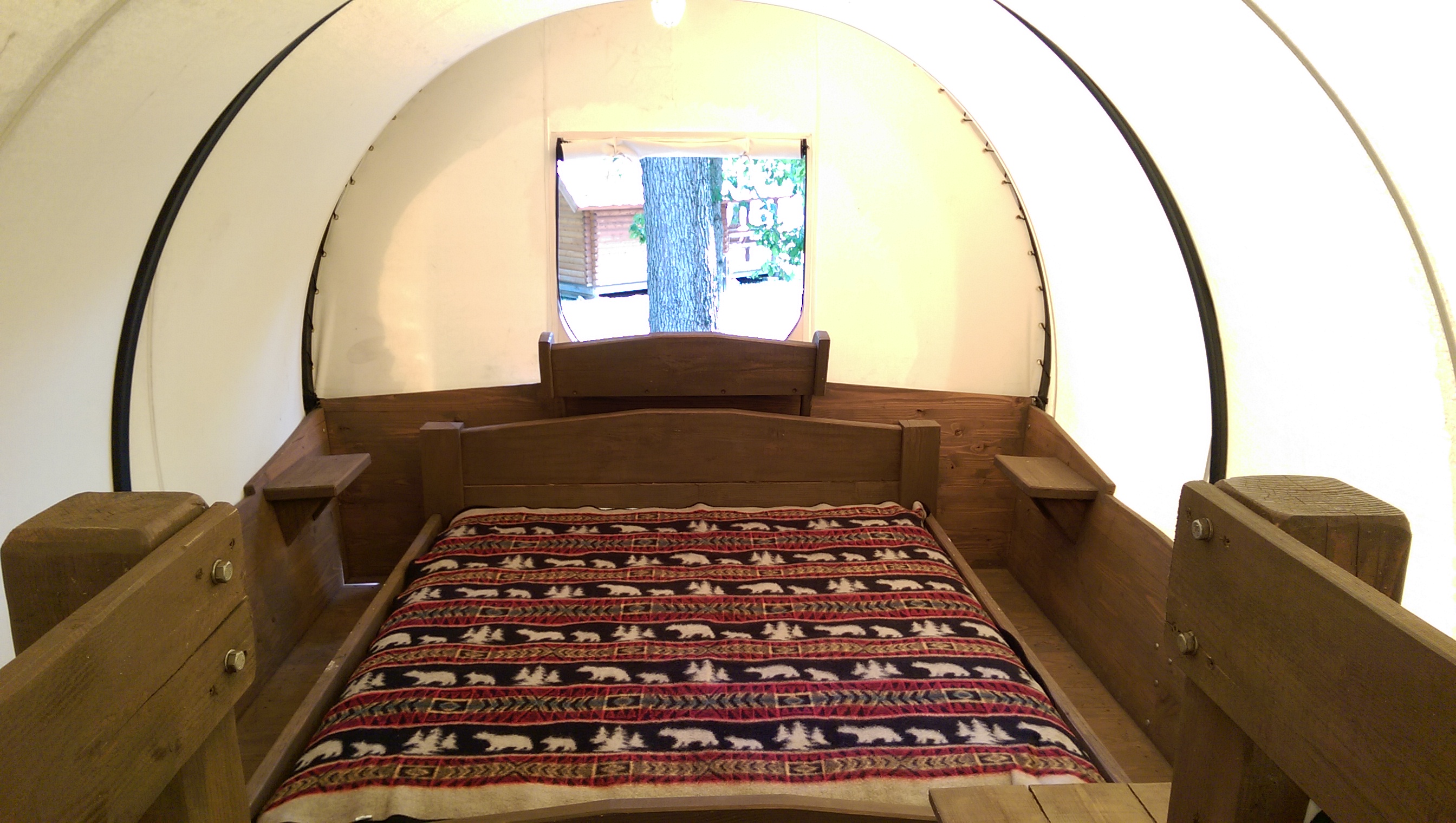 Snuggle down in a king-sized bed in the Conestoga wagon