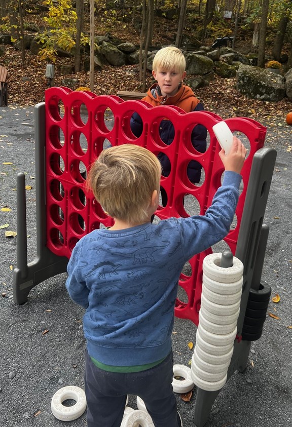 Kids playing giant Connect Four at Gettysburg KOA, enjoying outdoor camping games and activities.