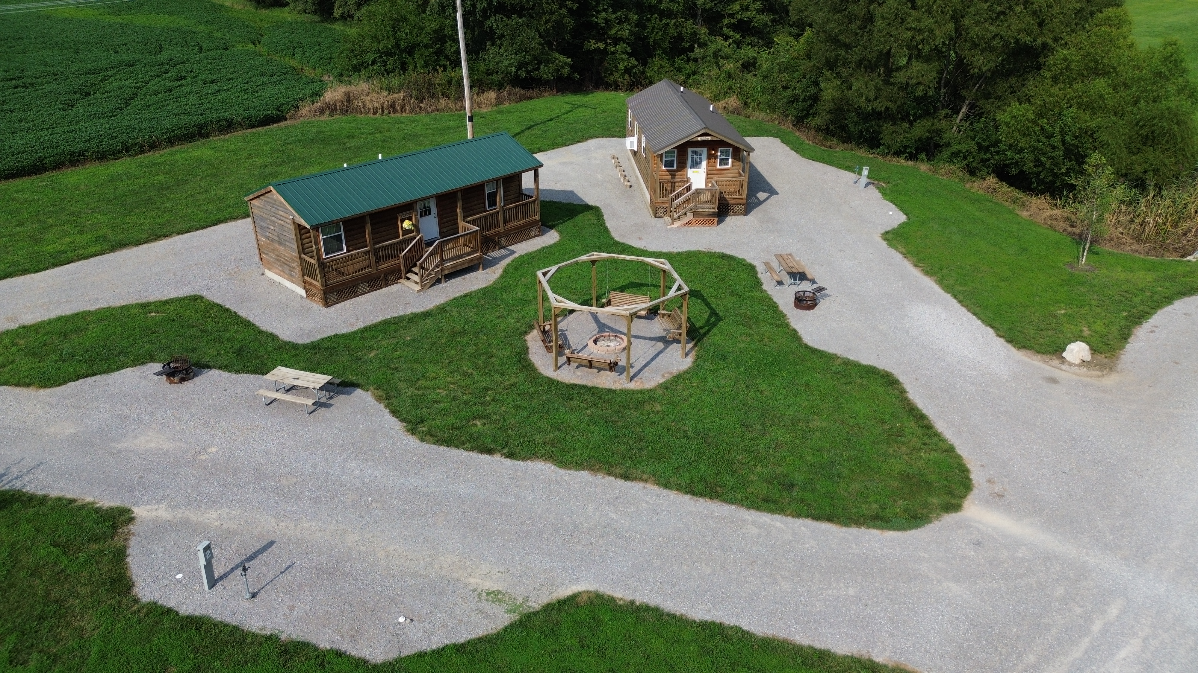 Pod 1 2 Rv Sites and 2 Cabins with a shared yard and a large swing set fire pit.