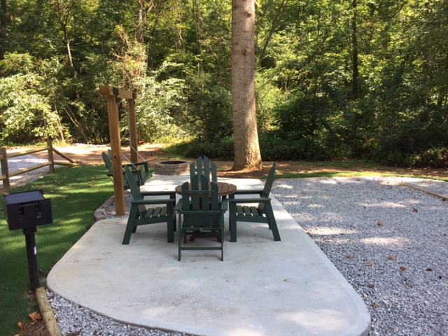 KOA Patio Site in our New Section in the back of the park. Concrete patio, table and chairs, swing, charcoal grill and fire pit.
