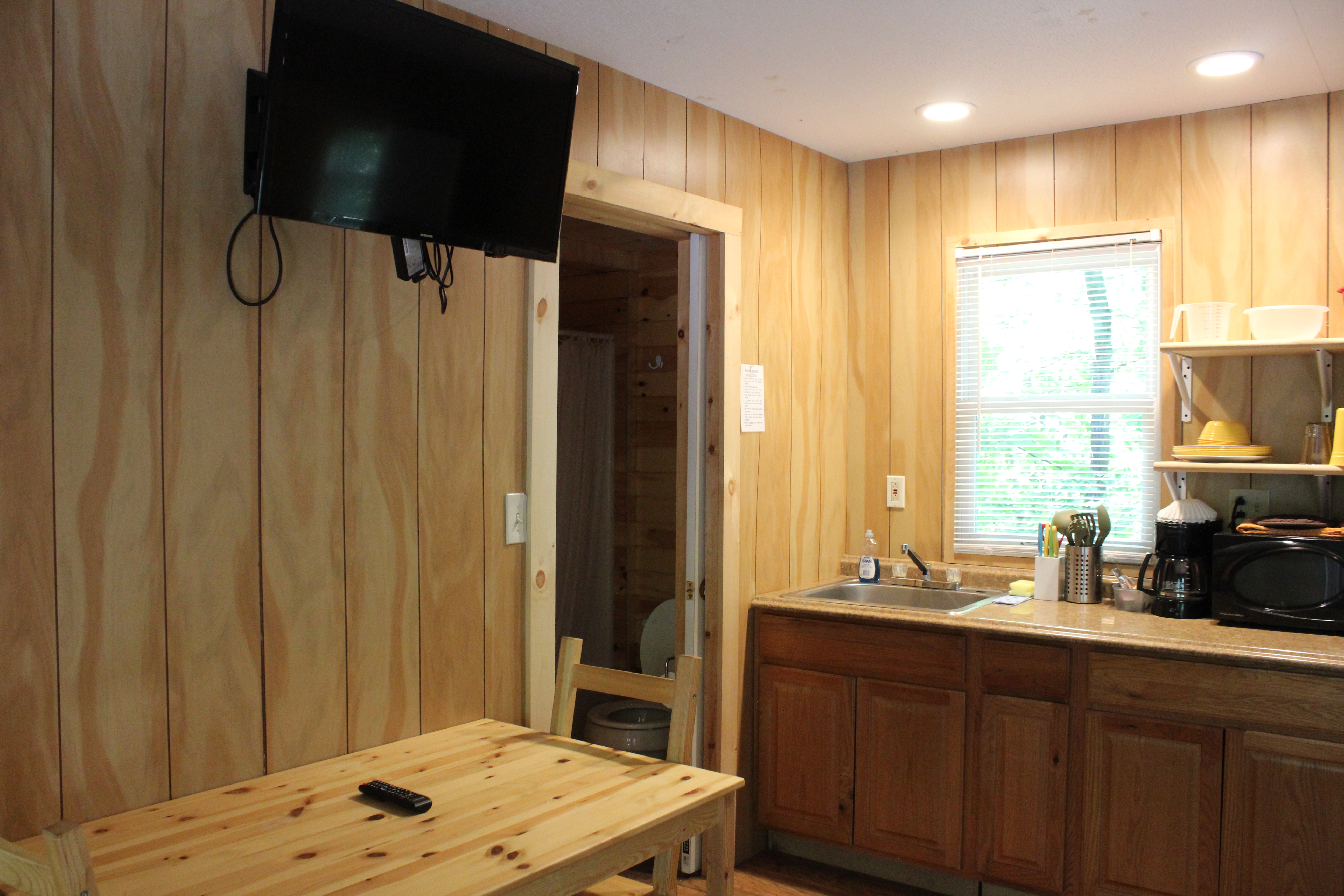 Deluxe Cabin - DK1 & DK2, Main living area with partial kitchen, table & chairs, and pull out full couch.