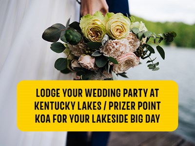 Bride holding a bouquet of pastel flowers near the end of a wooden lake pier