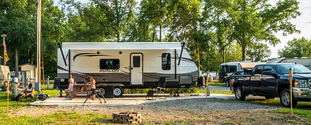 This is an overnight Back-in site at site 220. It is very spacious, has a concrete pad, picnic table, and another outdoor table with 6 chairs.