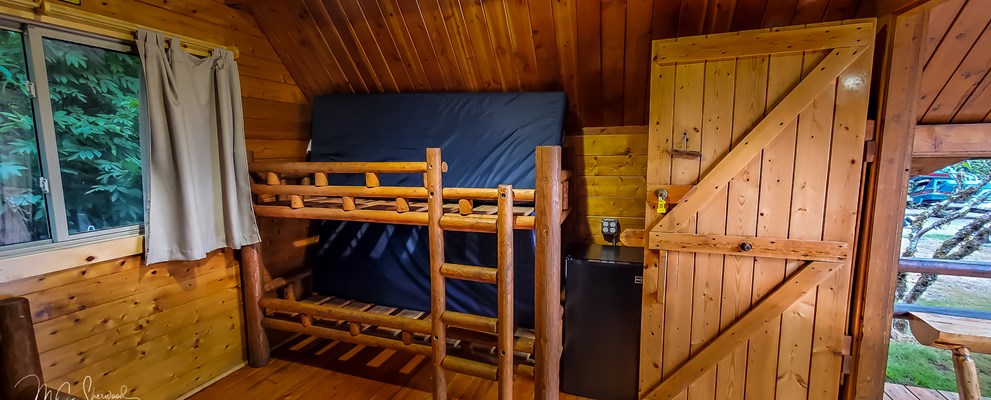 One-room rustic camping cabin interior - bunk beds