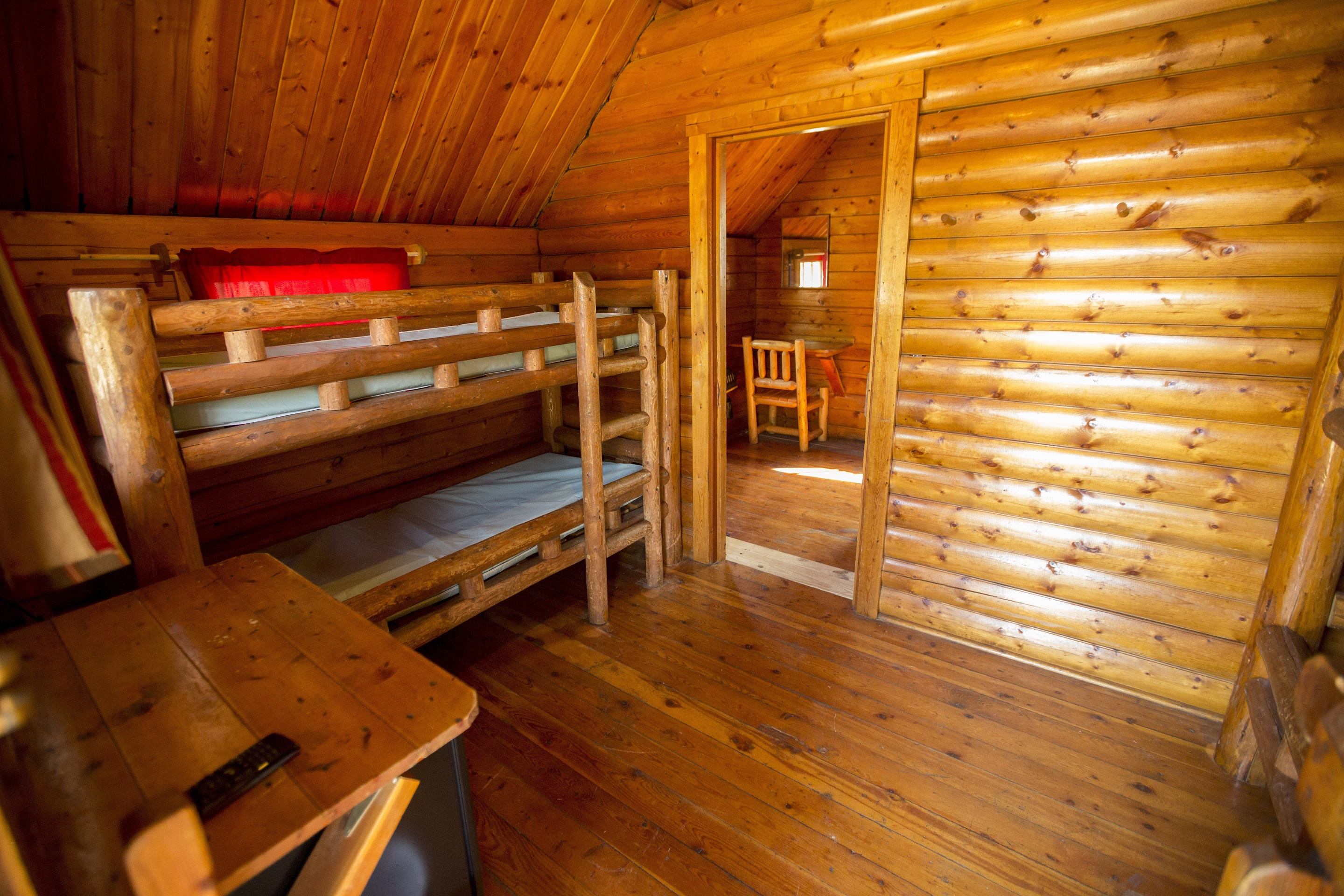Our 2 bedroom rustic cabins have 2 sets of bunk beds in the front room and a private master bedroom in the back bedroom.