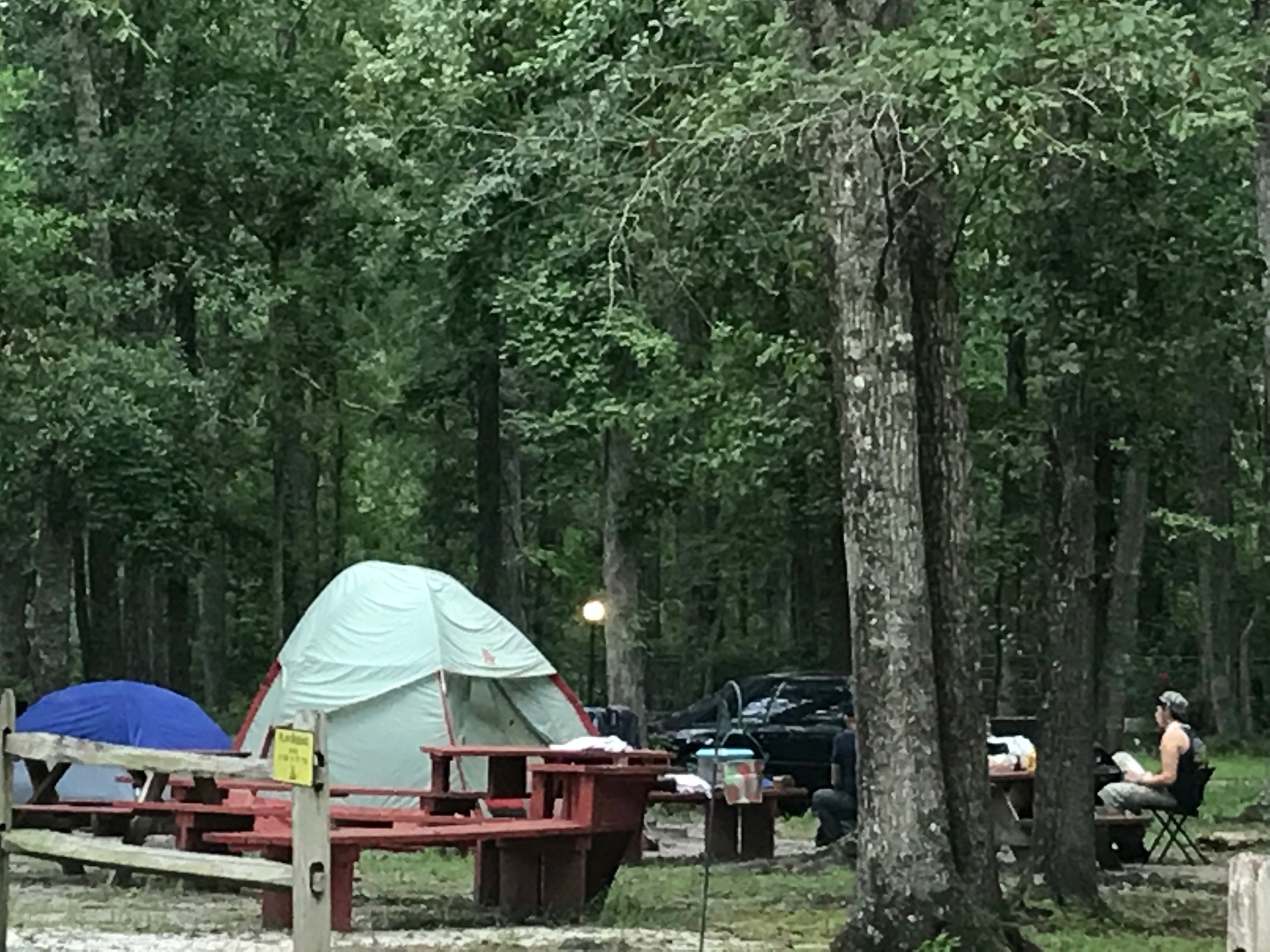 Primitive Tent site with Tent benches close to restroom, building and pavilion. Grills are available for any site.