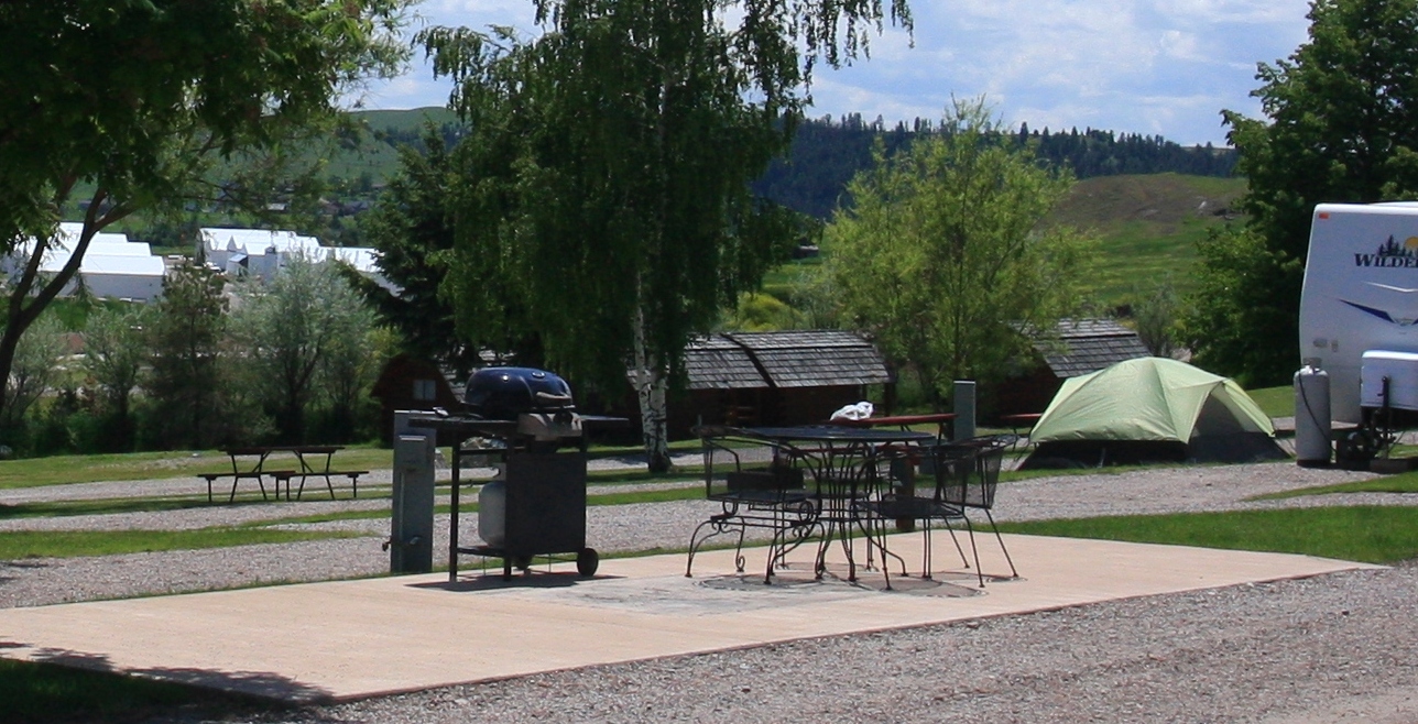 Gas grill, concrete patio with table and chairs