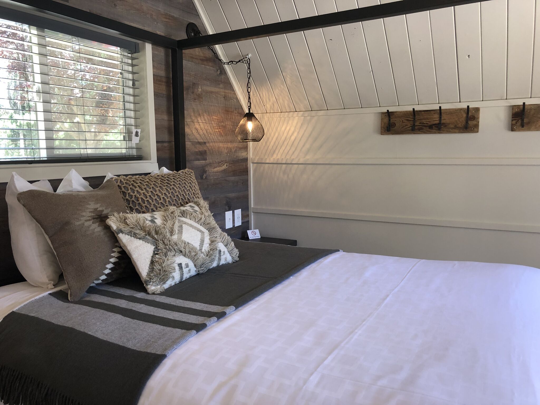 Queen bed with full linens in Patio Glamping Cabin