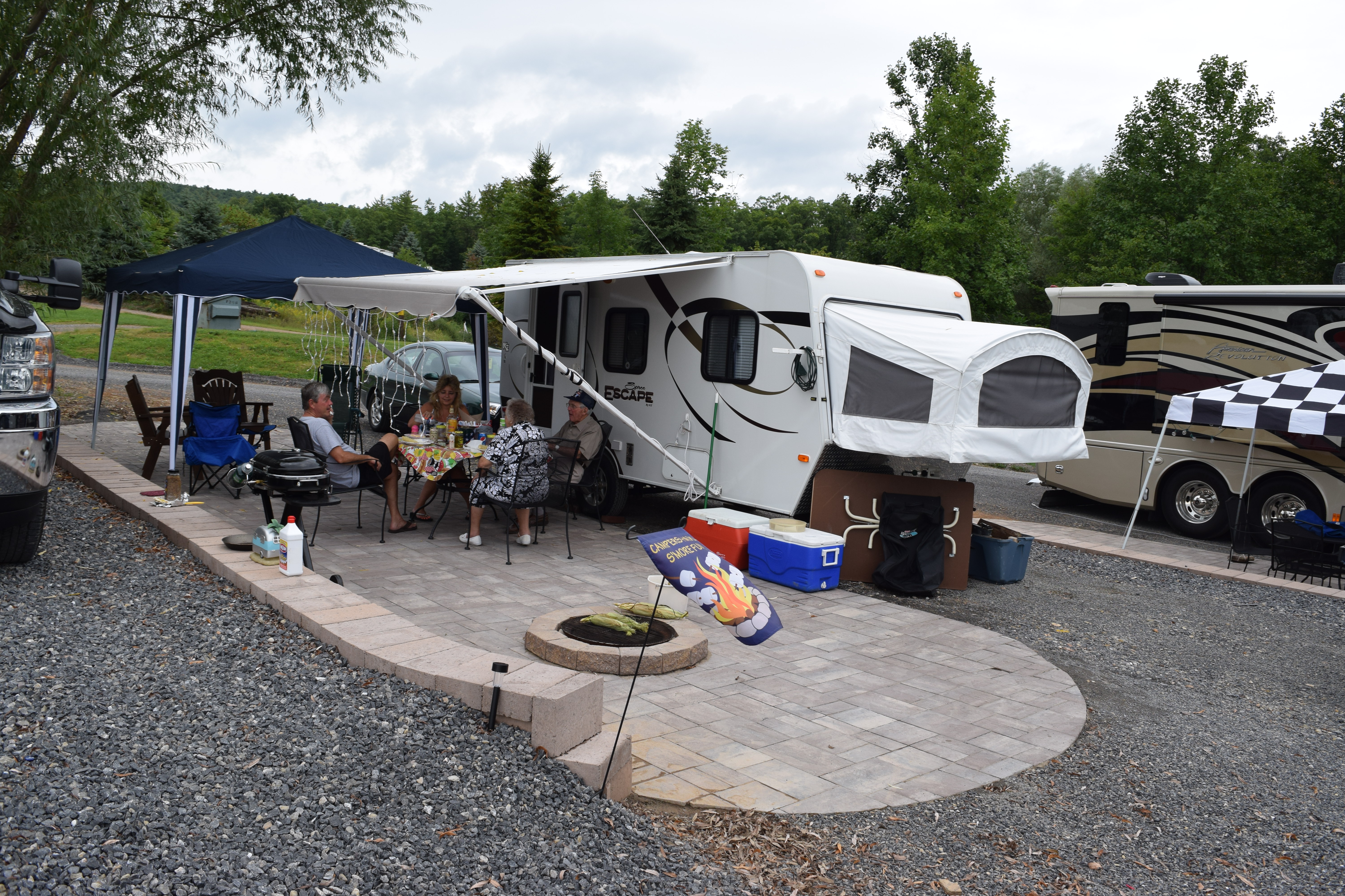 Deluxe Patio Pull Thru Site. Spacious site combined with a beautiful  patio, fire pit and outdoor furniture make for a great outdoor experience. 50/30amp elec. Non wooded.