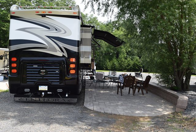 Deluxe Patio Pull Thru Site. Spacious site combined with a beautiful  patio, fire pit and outdoor furniture make for a great outdoor experience. 50/30amp elec. Non wooded.
