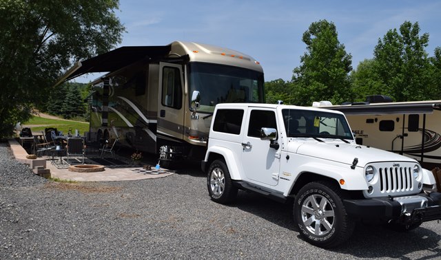 Deluxe Patio Pull Thru Site. Spacious site combined with a beautiful  patio, fire pit and outdoor furniture make for a great outdoor experience. 50/30amp elec. Non wooded.