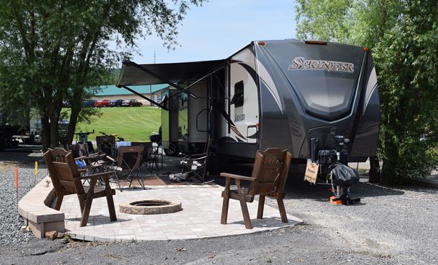 Deluxe Patio Pull Thru Site. Spacious site combined with a beautiful  patio, fire pit and outdoor furniture make for a great outdoor experience. 50/30amp elec. Non wooded.